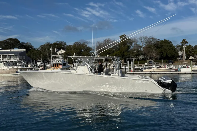 Slide: The Image of 2021 SeaHunter 41 CTS boat cruising on calm water near a marina. - 8