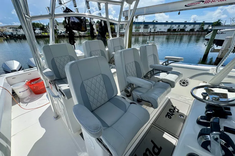 Slide: The Image of 2021 SeaHunter 41 CTS boat interior with luxurious seating and modern controls, docked by the water. - 10
