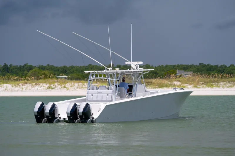 Slide: The Image of 2021 SeaHunter 41 CTS boat cruising near a sandy shoreline under a cloudy sky. - 24