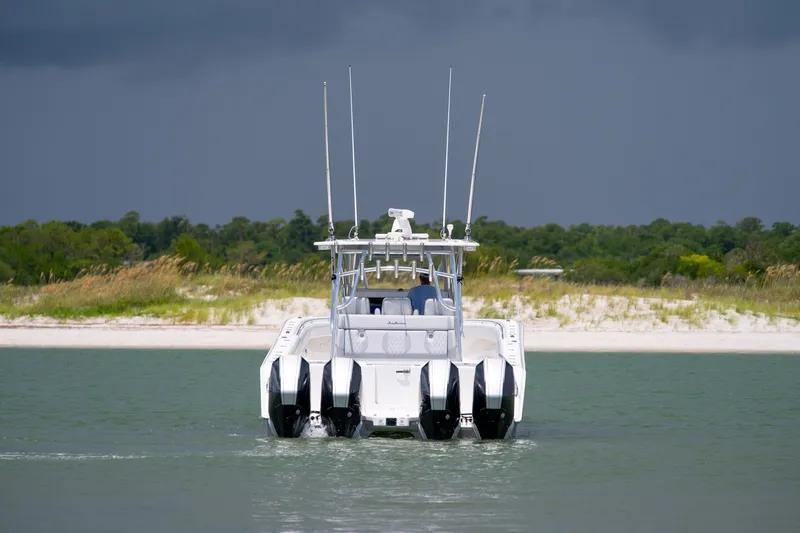 Slide: The Image of 2021 SeaHunter 41 CTS boat on water with sandy shoreline and dark sky. - 25