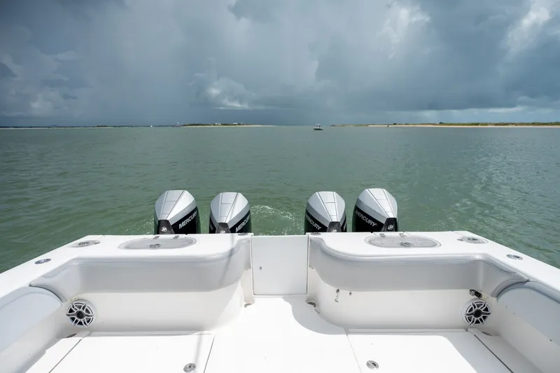 Slide: The Image of 2021 SeaHunter 41 CTS boat with four Mercury engines on a calm sea under cloudy skies. - 30
