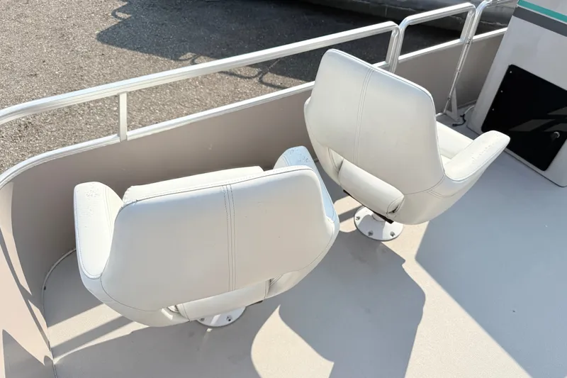 Slide: The Image of White swivel seats on a 1991 Harris FloteBote 240 pontoon boat deck. - 5