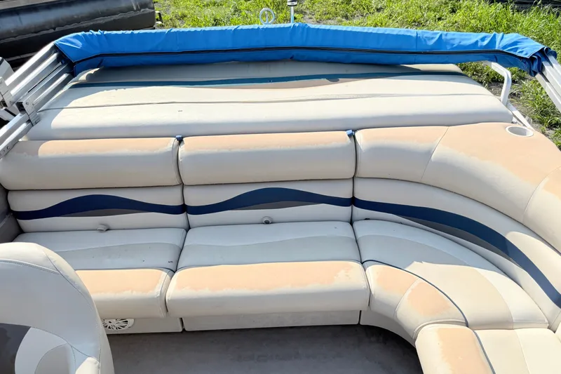 Slide: The Image of 1991 Harris FloteBote 240 pontoon boat interior with beige and blue seating. - 9
