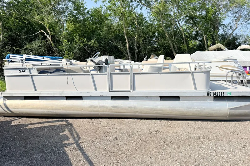 The Image of 1991 Harris FloteBote 240 pontoon boat parked on gravel with trees in background. - 1