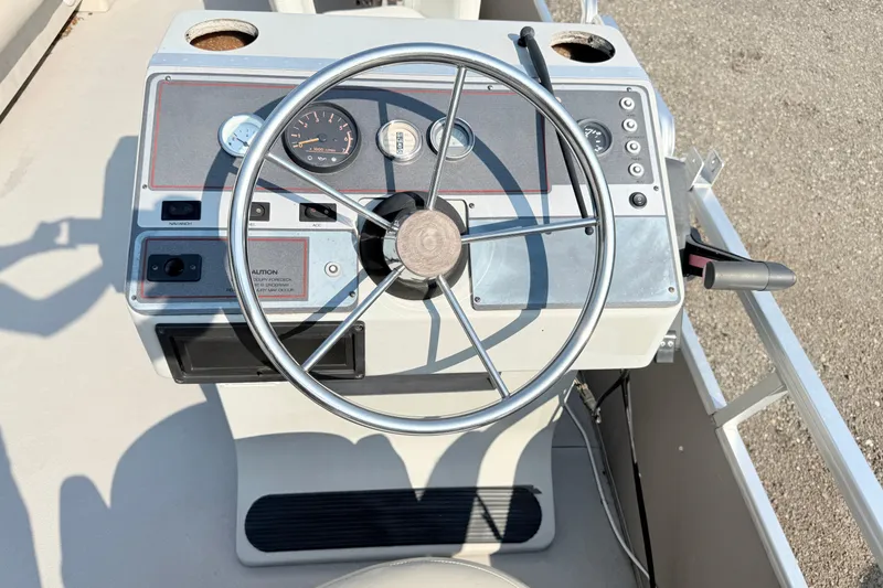 Slide: The Image of Steering console of a 1991 Harris FloteBote 240 pontoon boat with gauges and controls. - 11