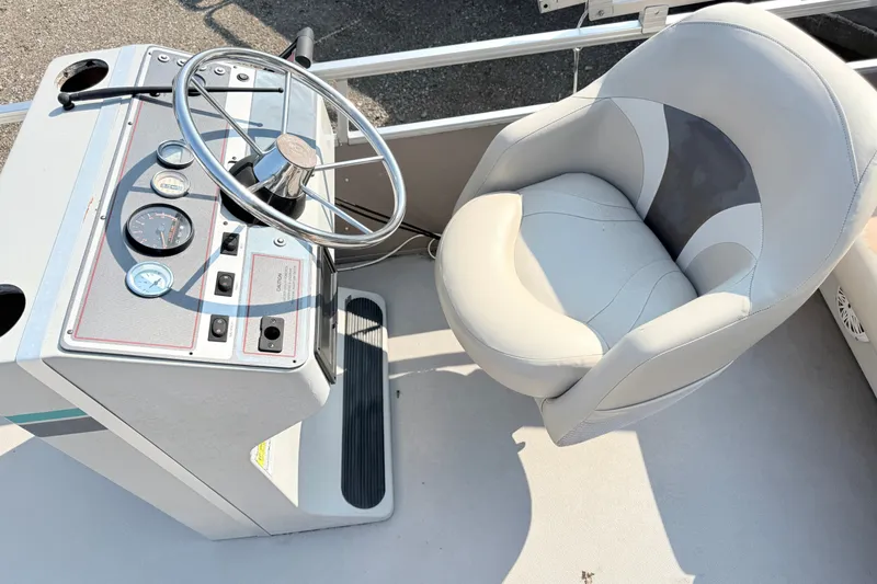 Slide: The Image of Steering console and seat of a 1991 Harris FloteBote 240 pontoon boat. - 10