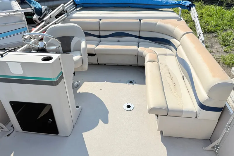 Slide: The Image of 1991 Harris FloteBote 240 pontoon boat interior with beige seating and steering console. - 6