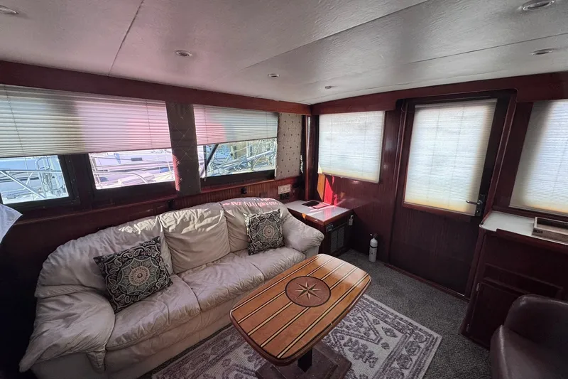 Slide: The Image of The interior of a 1981 Hatteras 43 Convertible features a cozy sofa and a wooden table. - 18
