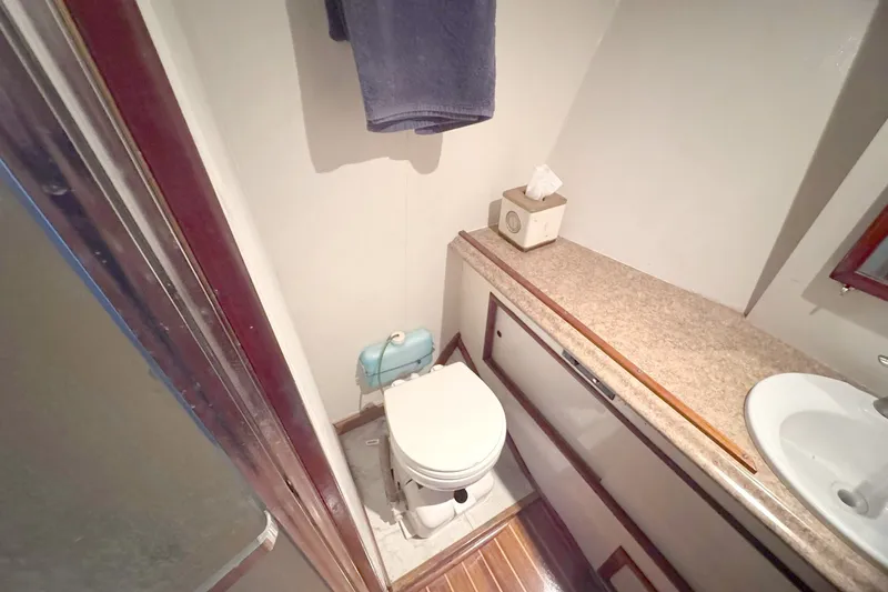 Slide: The Image of 1981 Hatteras 43 Convertible yacht bathroom with toilet, sink, and countertop. - 38