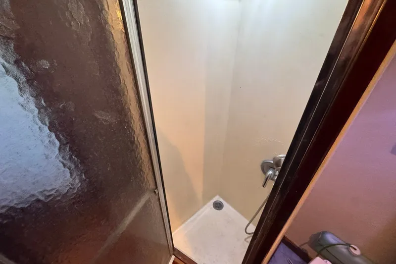 Slide: The Image of Shower area inside 1981 Hatteras 43 Convertible yacht, featuring glass door and compact design. - 39