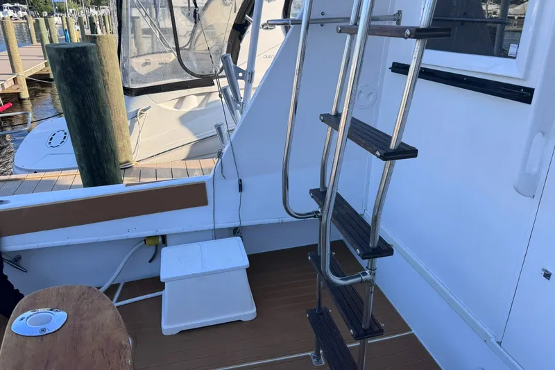 Slide: The Image of 1981 Hatteras 43 Convertible boat deck with ladder and dock view. - 13
