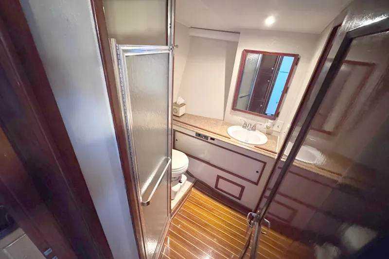 Slide: The Image of 1981 Hatteras 43 Convertible yacht bathroom with shower, sink, and wooden flooring. - 37