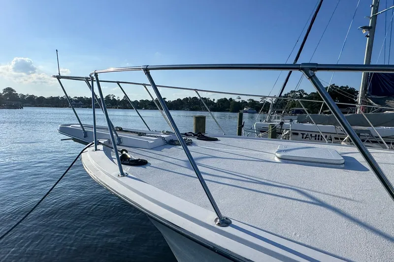 Slide: The Image of 1981 Hatteras 43 Convertible yacht docked on a sunny day, showcasing sleek deck design. - 65