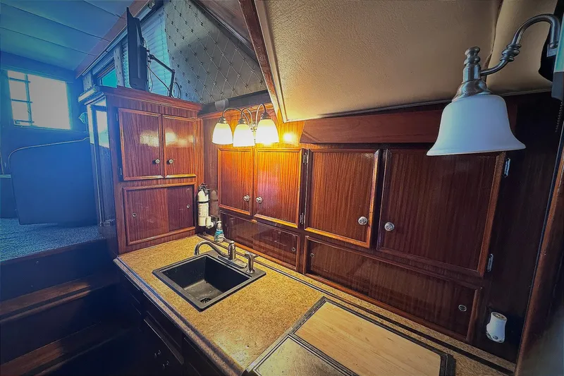 Slide: The Image of 1981 Hatteras 43 Convertible yacht interior with wooden cabinets and sink. - 31