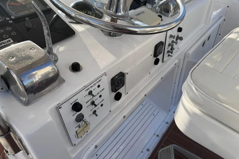 Slide: The Image of 1981 Hatteras 43 Convertible boat control panel with steering wheel and switches. - 46