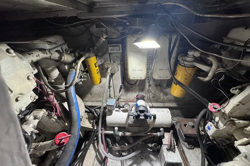 Slide: The Image of Engine room of a 1981 Hatteras 43 Convertible boat, showcasing mechanical components and wiring. - 80