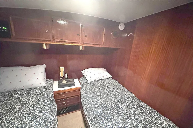 Slide: The Image of Cabin interior of 1981 Hatteras 43 Convertible with twin beds and wooden cabinetry. - 43