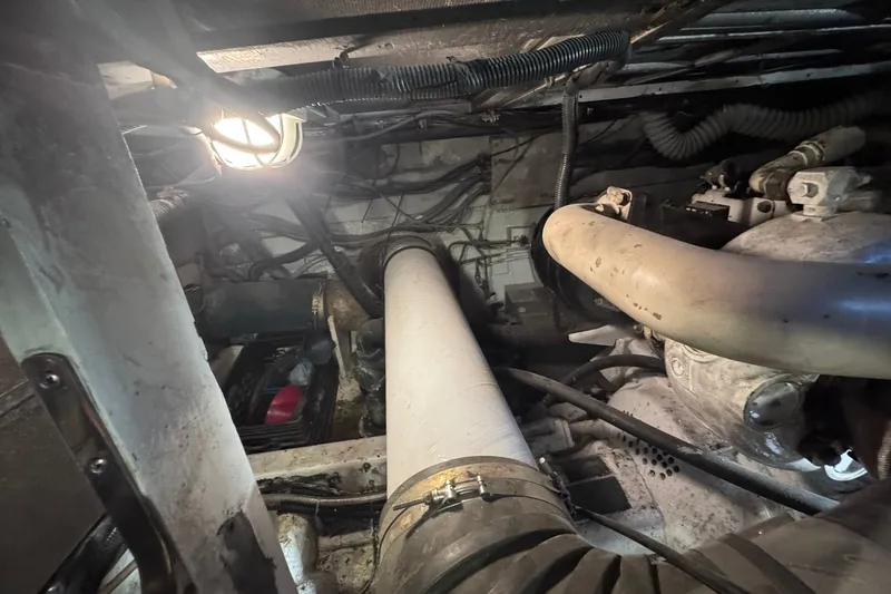 Slide: The Image of Engine room of a 1981 Hatteras 43 Convertible boat, showing pipes and machinery. - 73