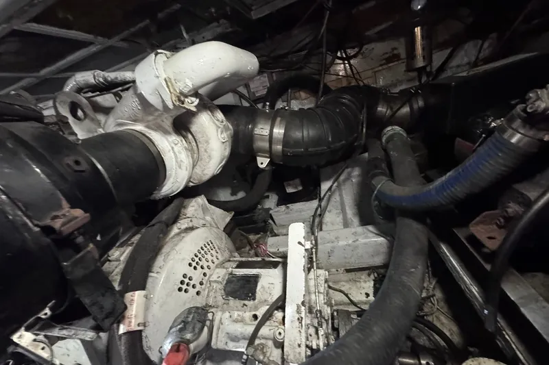 Slide: The Image of Engine room of a 1981 Hatteras 43 Convertible boat, showing complex machinery and pipes. - 71