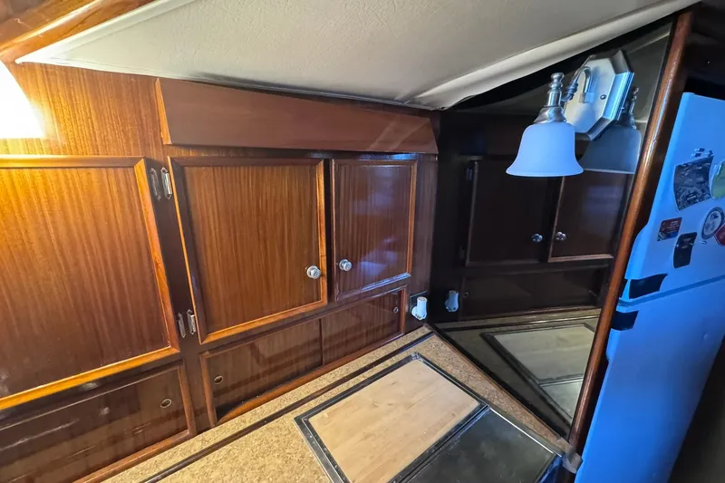 Slide: The Image of Interior of 1981 Hatteras 43 Convertible yacht with wooden cabinets and modern lighting. - 32