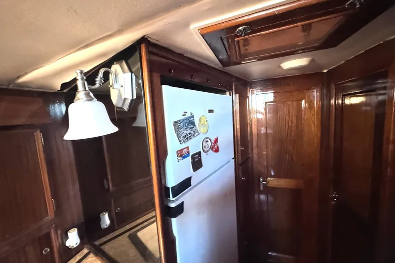 Slide: The Image of Interior of 1981 Hatteras 43 Convertible yacht with wooden cabinetry and refrigerator. - 33