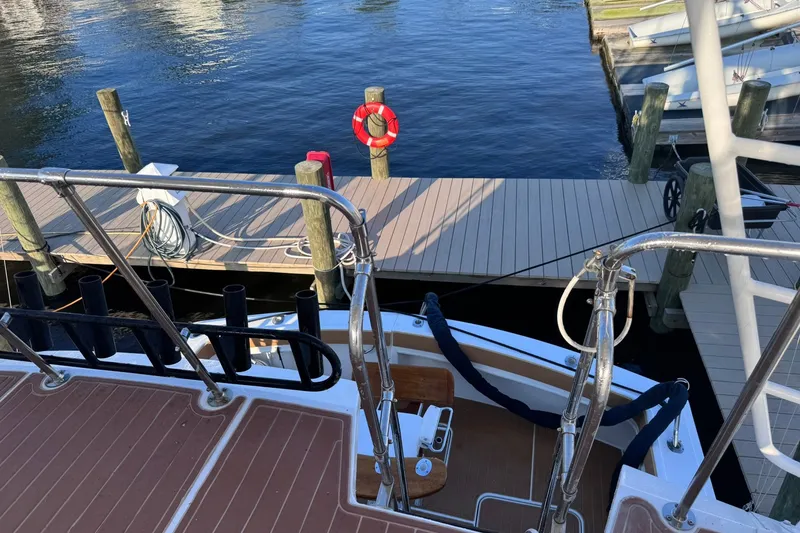 Slide: The Image of 1981 Hatteras 43 Convertible yacht docked at marina with lifebuoy and mooring lines. - 63