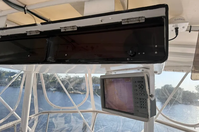 Slide: The Image of 1981 Hatteras 43 Convertible cockpit with Garmin navigation system, overlooking serene waters. - 53