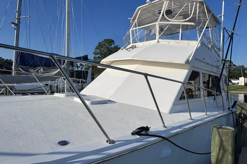 Slide: The Image of 1981 Hatteras 43 Convertible yacht docked at marina under clear blue sky. - 64