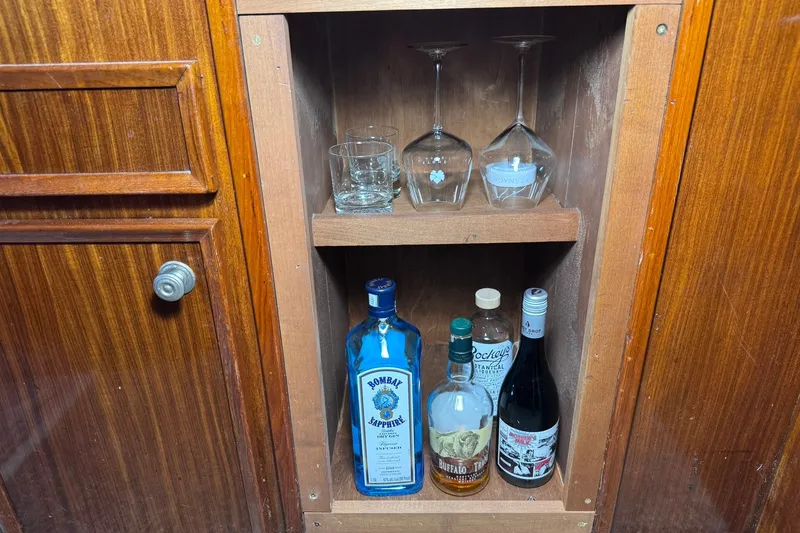 Slide: The Image of Wooden cabinet with glassware and assorted liquor bottles on a 1981 Hatteras 43 Convertible yacht. - 24