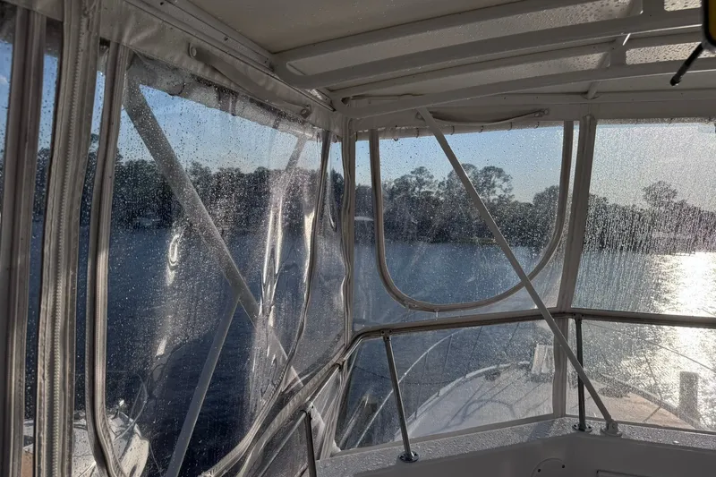 Slide: The Image of Interior view of 1981 Hatteras 43 Convertible boat with clear enclosure and water droplets. - 56