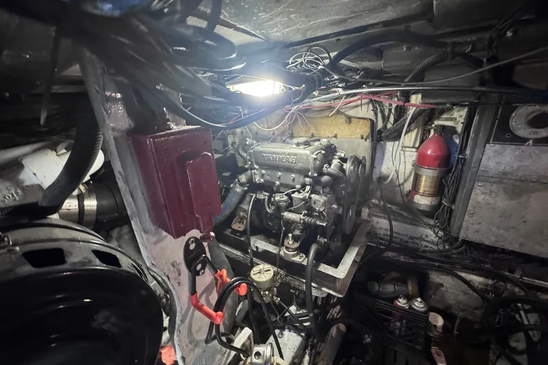 Slide: The Image of Engine room of a 1981 Hatteras 43 Convertible boat, showcasing mechanical components and wiring. - 70