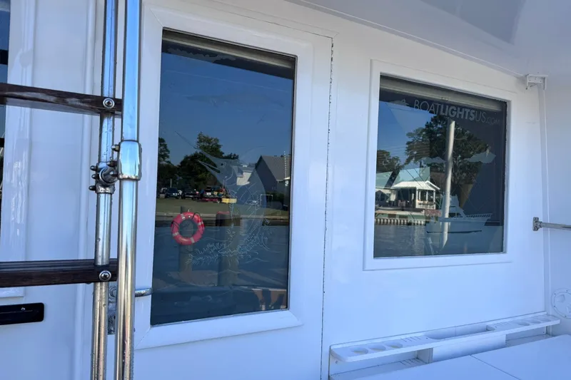 Slide: The Image of 1981 Hatteras 43 Convertible boat exterior with reflective windows and dockside view. - 14
