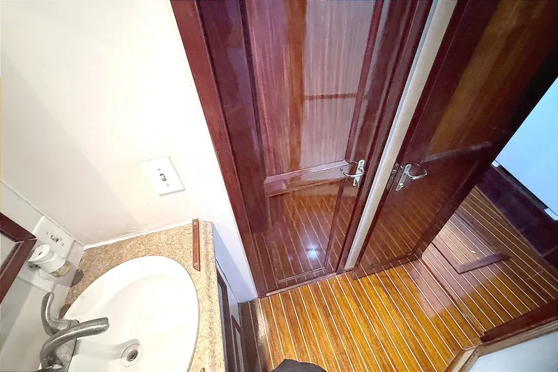 Slide: The Image of Bathroom interior of 1981 Hatteras 43 Convertible yacht with wooden flooring and sink. - 41