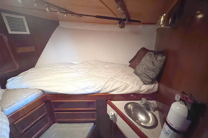 Slide: The Image of Cozy cabin interior of 1981 Hatteras 43 Convertible with bed, sink, and storage. - 36