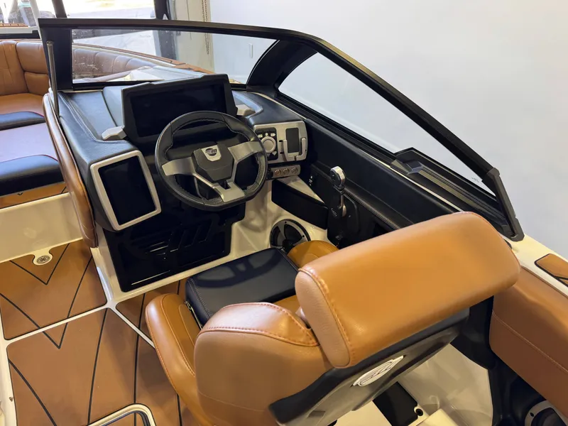 Slide: The Image of The image shows the cockpit of a 2021 Malibu Wakesetter 23 LSV with brown leather seats. - 24