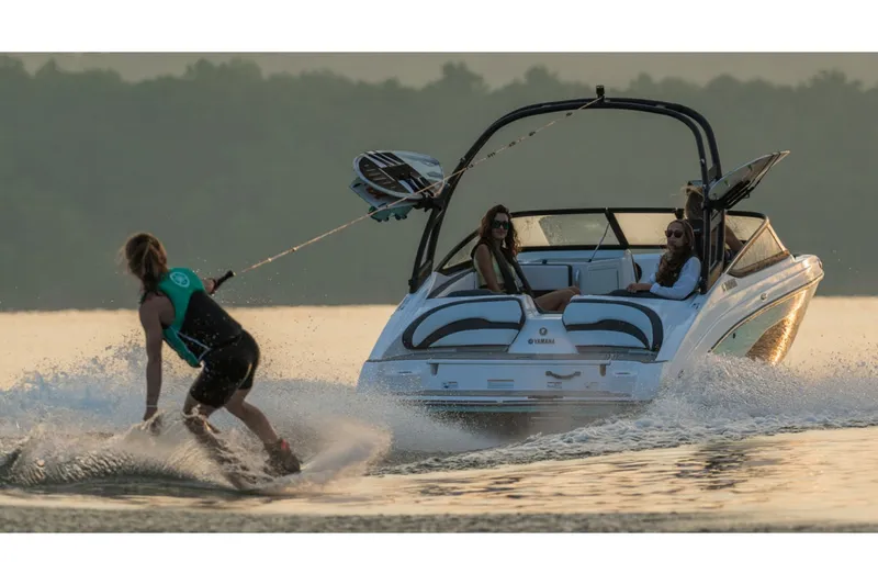 Slide: The Image of A 2026 Yamaha AR195 pulls a wakeboarder across calm water at sunset. - 11