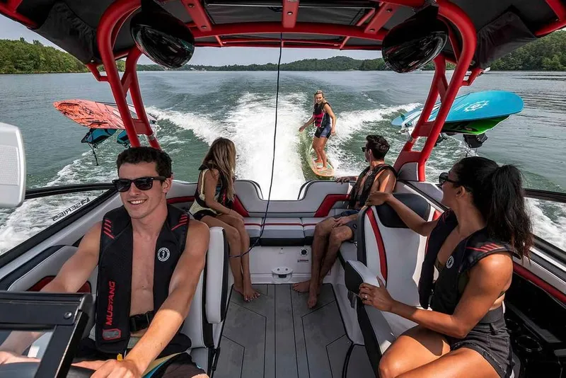 Slide: The Image of A group of people enjoying watersports on a Yamaha 242X boat. A surfer rides the wake behind the boat. - 23