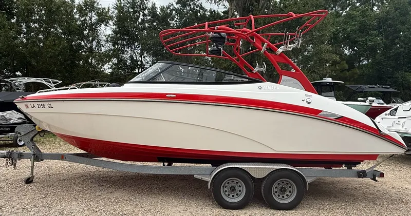 Slide: The Image of A 2020 Yamaha 242X boat with a red and white hull on a trailer. - 4