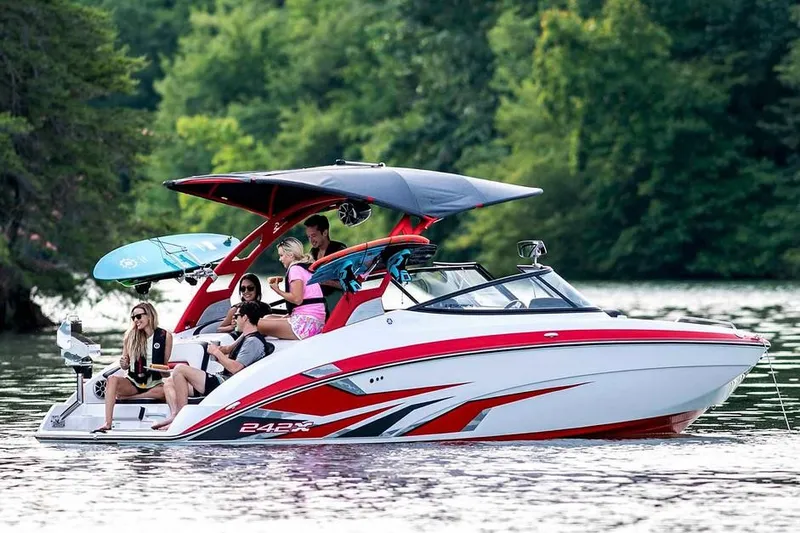 Slide: The Image of A 2020 Yamaha 242X cruising on a calm lake, surrounded by trees. - 20