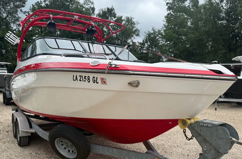 Slide: The Image of A red and white 2020 Yamaha 242X boat on a trailer, surrounded by trees. - 3