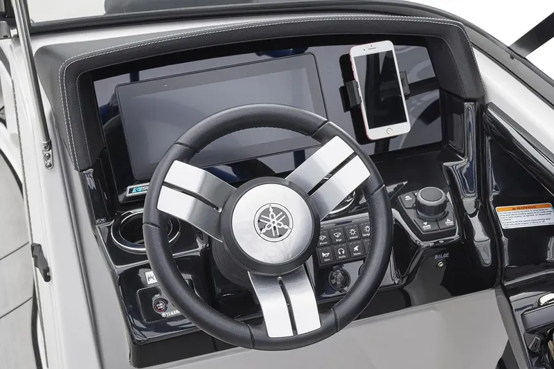 Slide: The Image of The image shows the helm of a Yamaha 242X boat with a modern dashboard and a smartphone holder. - 24