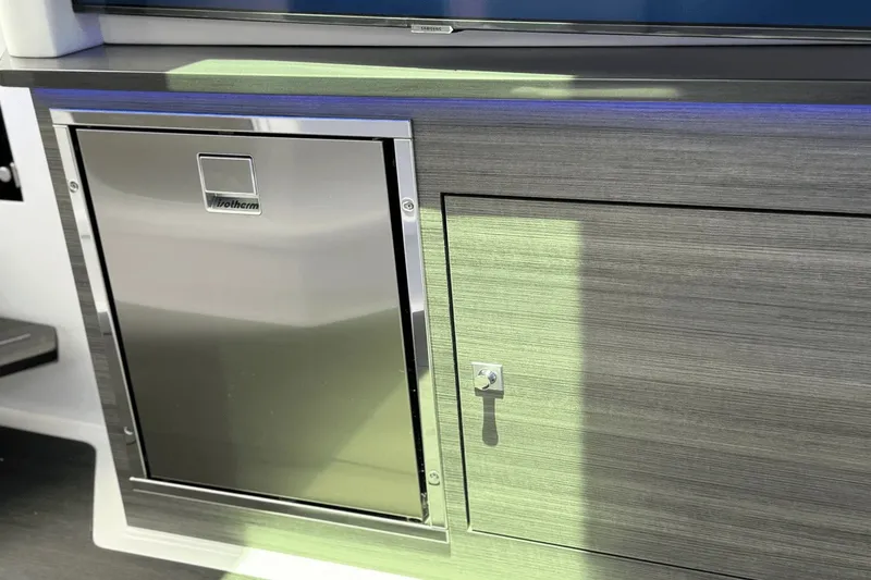 Slide: The Image of The 2024 Aviara AV40 OB features a sleek refrigerator and storage area with modern finishes. - 34