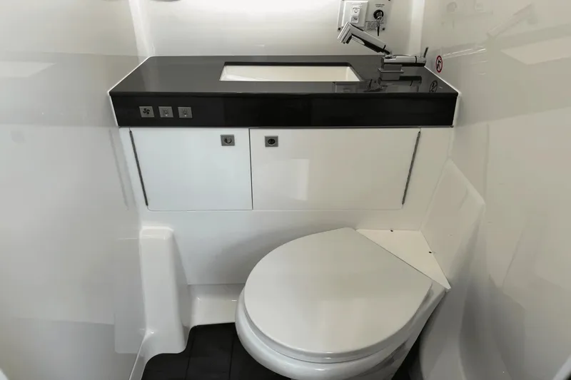 Slide: The Image of The image shows a modern boat bathroom with a toilet and a sink. - 35