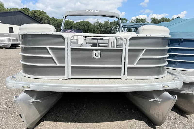 Slide: The Image of 2020 Godfrey Sweetwater 2286 C pontoon boat in a parking lot under a blue sky. - 2