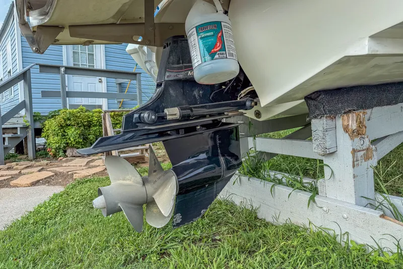 Slide: The Image of 2011 Cobalt 210 boat propeller and outdrive on a wooden stand, with cleaning supplies nearby. - 29