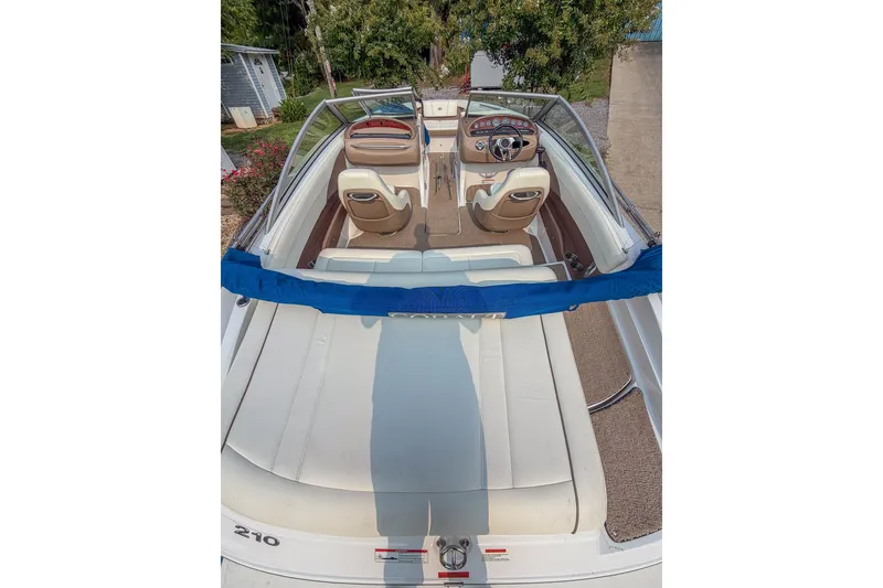Slide: The Image of 2011 Cobalt 210 boat interior with seating and steering wheel, docked outdoors. - 18