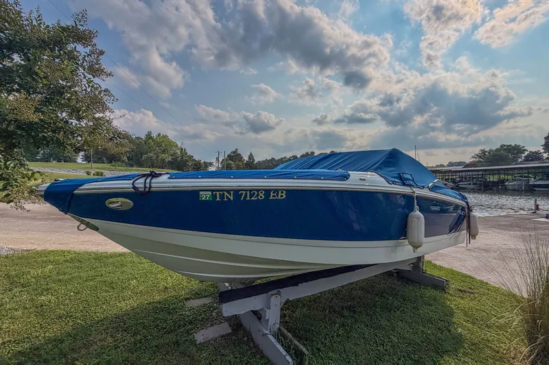 Slide: The Image of Blue 2011 Cobalt 210 boat on trailer by lakeside under cloudy sky. - 7