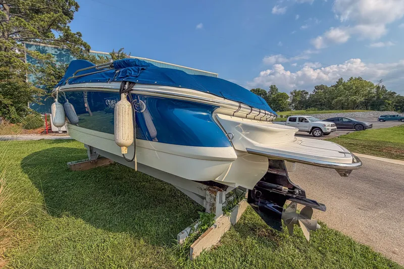 Slide: The Image of 2011 Cobalt 210 boat with blue cover on grassy area, sunny day. - 4
