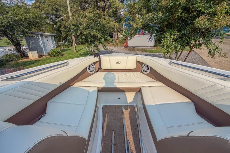 Slide: The Image of Interior of a 2011 Cobalt 210 boat with white seating and outdoor background. - 8