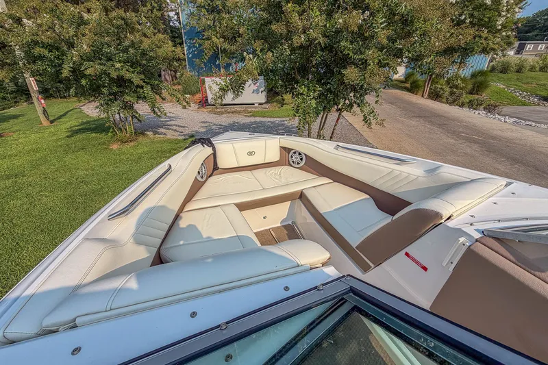 Slide: The Image of 2011 Cobalt 210 boat interior with white seating, surrounded by greenery. - 10